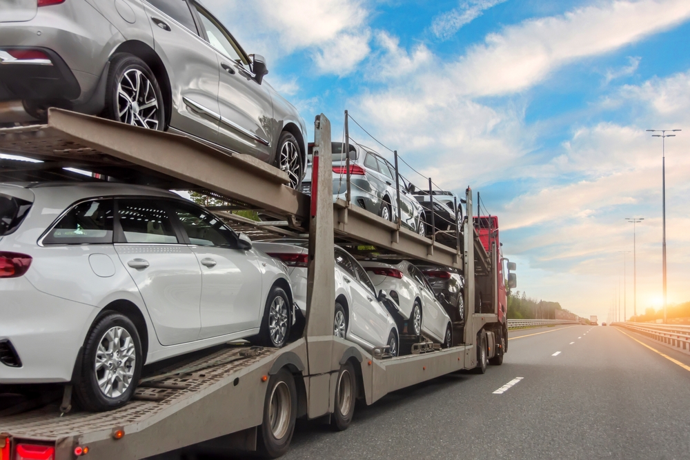 A car carrier truck transporting multiple vehicles on a highway.